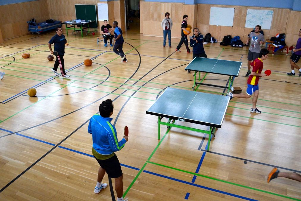 zur Vergrößerungsansicht des Bildes: ein Tischtennisgruppe trainiert in der Halle