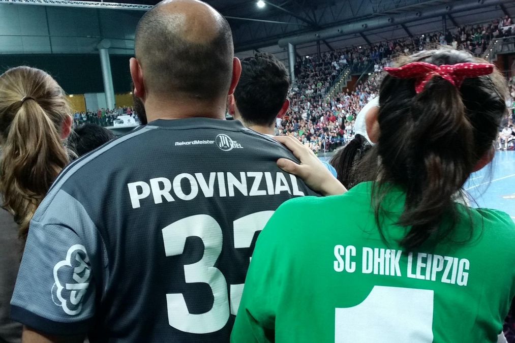 enlarge the image: Ein Teilnehmer und eine Teilnehmerin sehen einem Handballspiel in der Arena Leipzig zu. 
