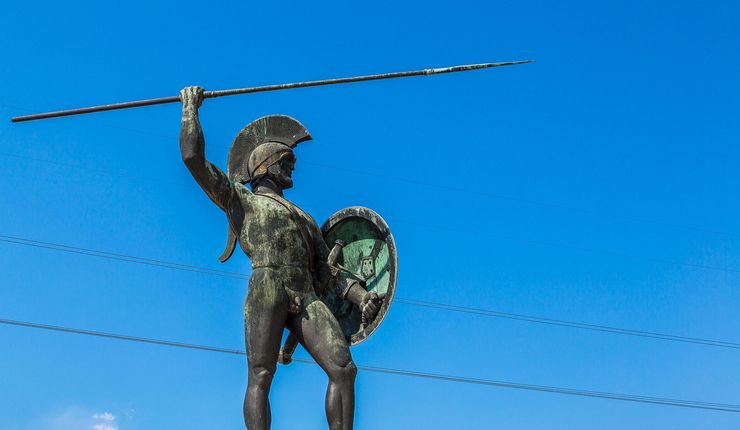 The image shows a statue of Statue of Leonidas, King of Sparta in front of a blue sky on a summer day in Thermopylae, Greece