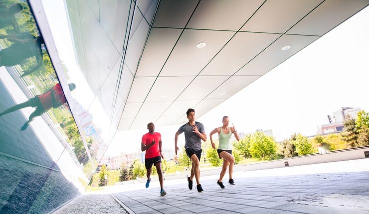 Das Bild zeigt drei Personen bei gemeinsamen Laufsportaktivitäten im Freien