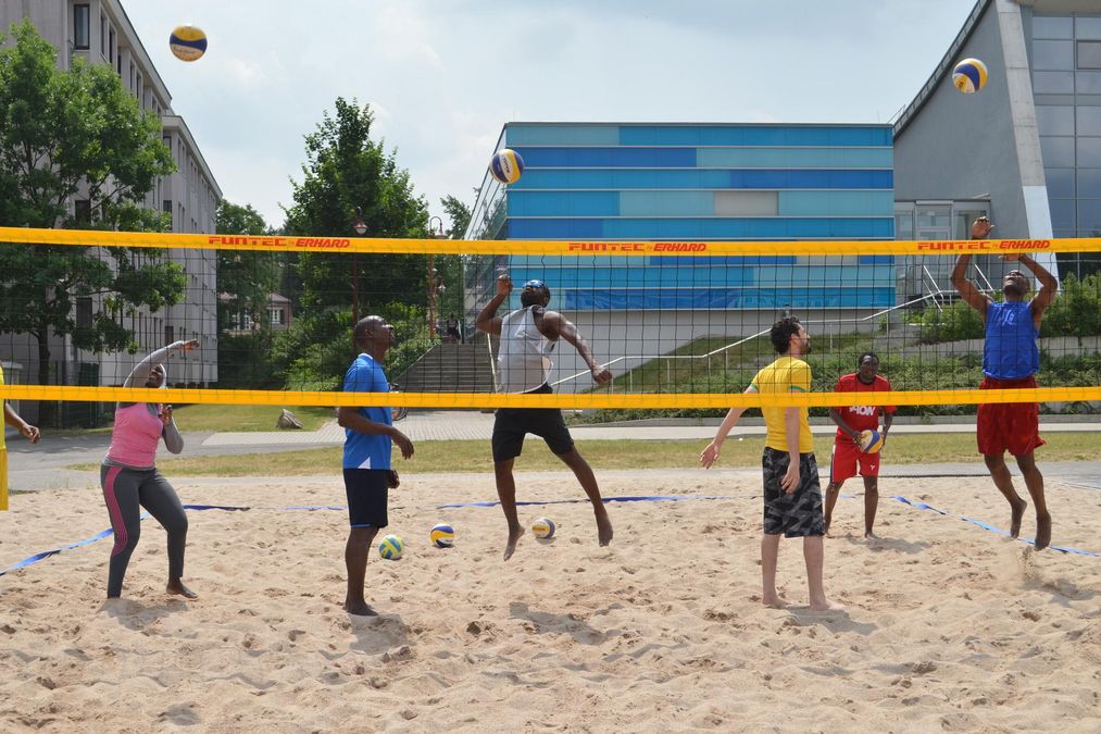 zur Vergrößerungsansicht des Bildes: zwei Mannschaften spielen Beachvolleyball
