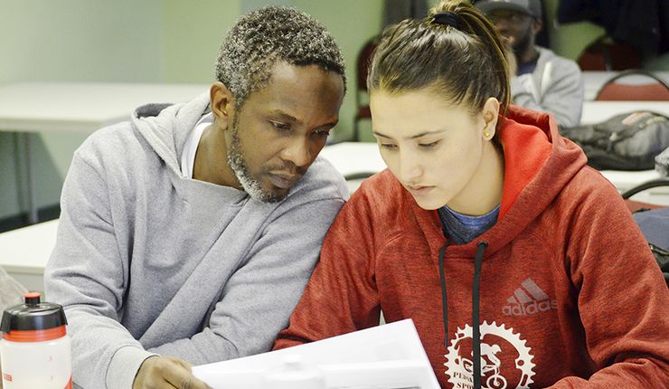 Students of the International Sports Development Programme reading a paper