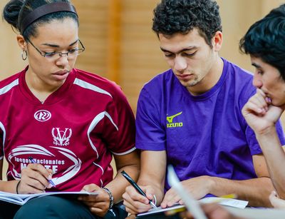 three students of the Master's programme in International Sports Development discussing their work