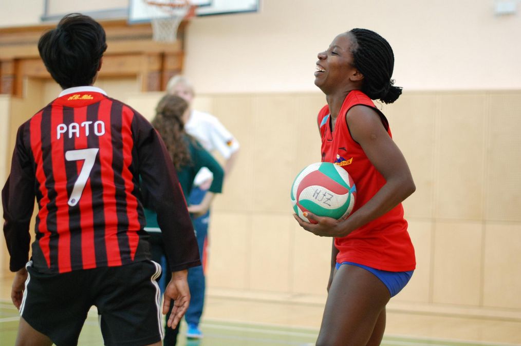 zur Vergrößerungsansicht des Bildes: eien Volleyballerin hält den Ball und lacht herzlich