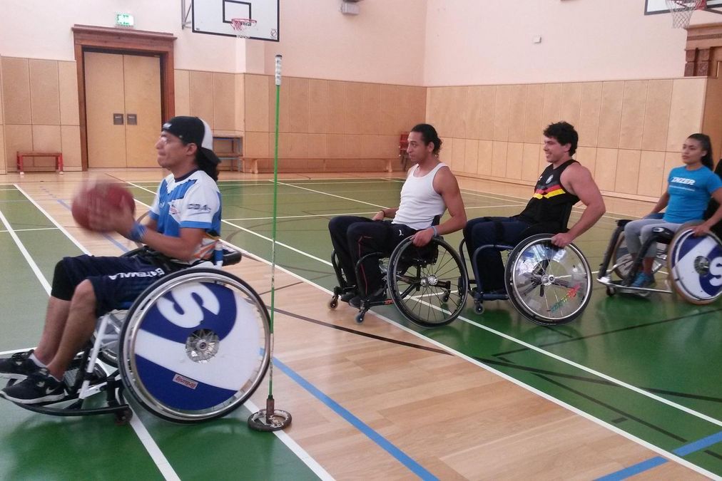 zur Vergrößerungsansicht des Bildes: eine Gruppe übt Rollstuhlbasketball