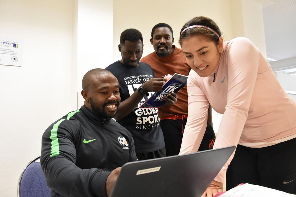 enlarge the image: vier Studenten schauen sich im Computer etwas an