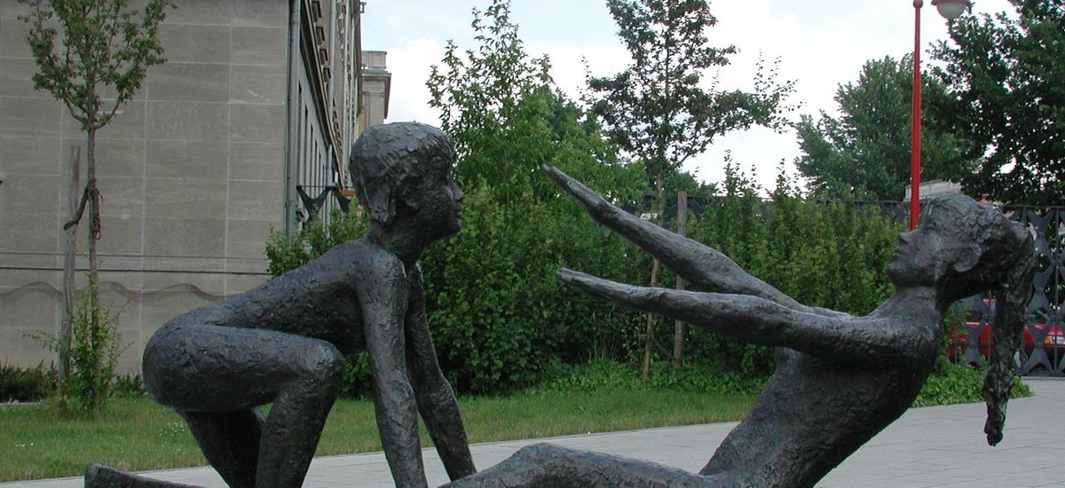 Gymnastikskulptur vor dem Campus Jahnallee, bei der zwei Personen zusammen eine Kräftigungsübung für den Bauch ausführen