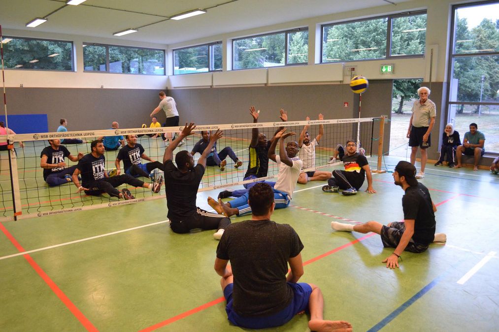 enlarge the image: Zwei Mannschaften spielen Sitzvolleyball.