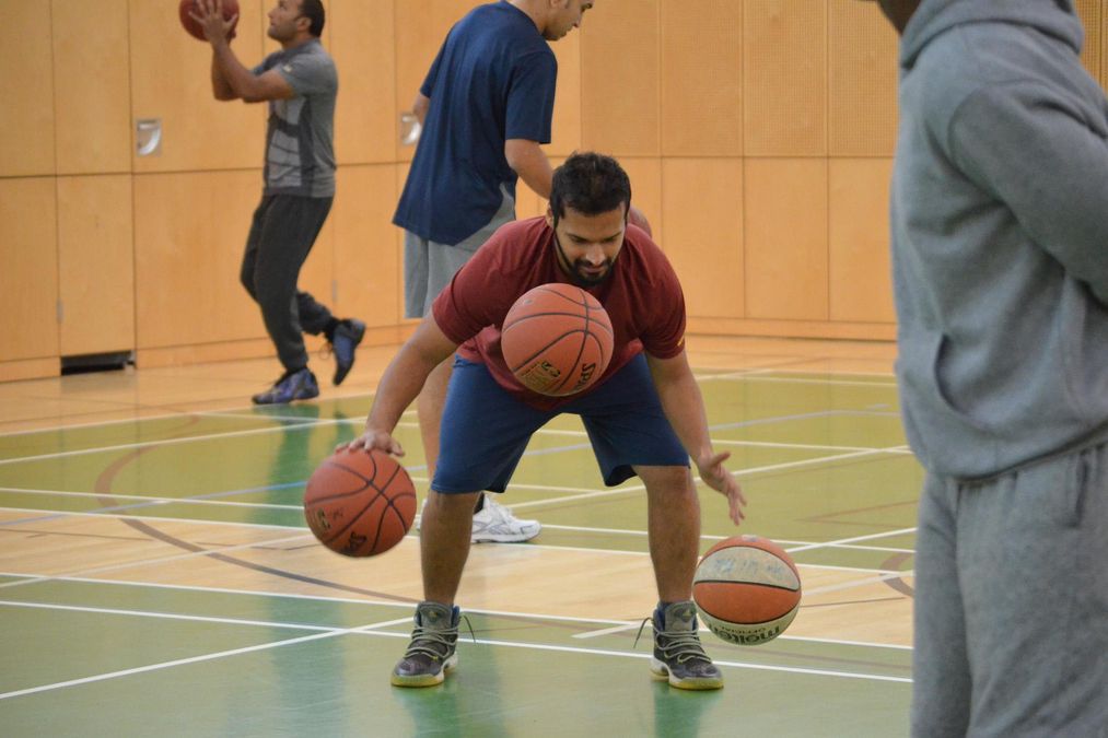Ein Basketballspieler übt mit drei Bällen, er versucht, alle drei in Bewegung zu halten.