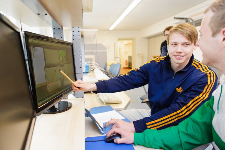 Zwei Studenten sitzen sich gegenüber und vor ihnen stehen Bildschirme mit Messergebnissen, Foto: Christian Hüller