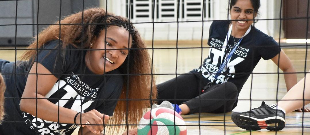 eine Spielerin liegt mit dem Volleyball am Boden und lacht