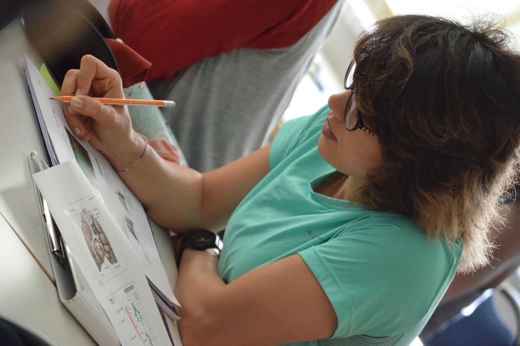 zur Vergrößerungsansicht des Bildes: Eine Studentin macht sich Notizen im Unterricht Sportmedizin