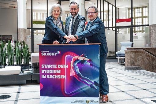 Rektorin Obergfell, Minister Gemkow und Rektor Kratzsch stehen an einem Tresen mit der Aufschrift "Starte dein Studium in Sachsen".
